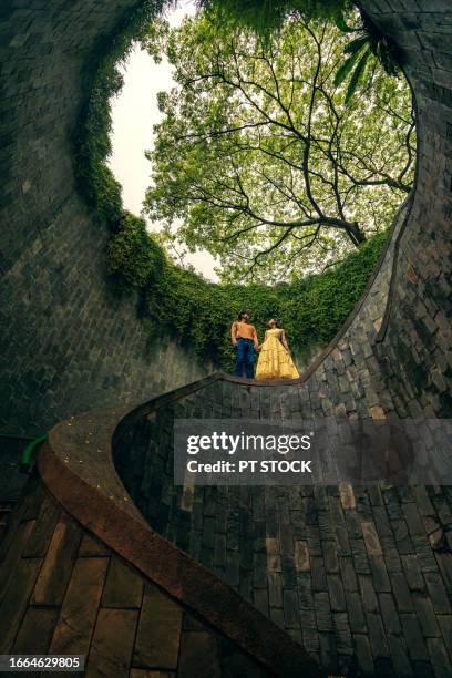 men and women, fort canning tree tunnel, singapore. on a rainy day, a popular place for tourists to take pictures is the tunnel-like structure covered with green trees. - fortress gate and staircases bildbanksfoton och bilder