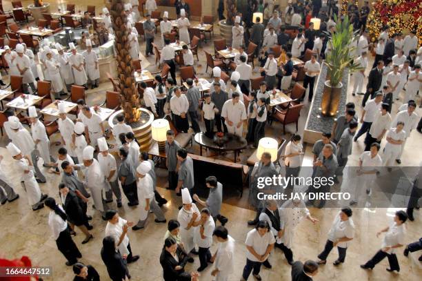 The management of the Peninsula meets with the employees in the lobby of the five-star Manila hotel as it reopens for business, 03 December 2007,...