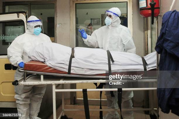 In this photograph taken on September 12 health workers wearing protective gear shift the body of a person who died of a Nipah virus infection at a...