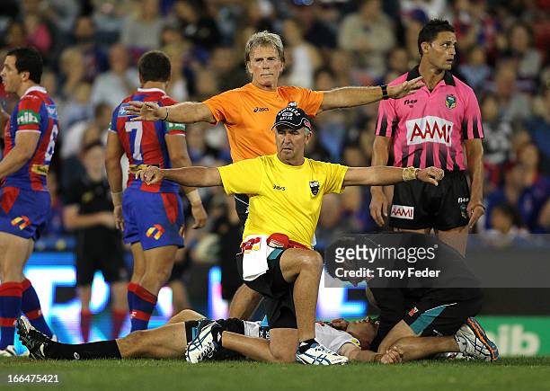 Trainers signal for a stretcher to carry off injured player, Matt Robinson of the Panthers during the round six NRL match between the Newcastle...
