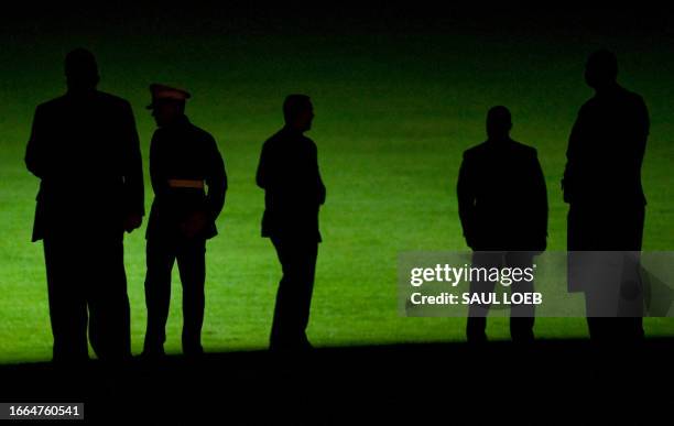 Security personnel and White House staff await Marine One's arrival, the presidential helicopter carrying US President Barack Obama and First Lady...