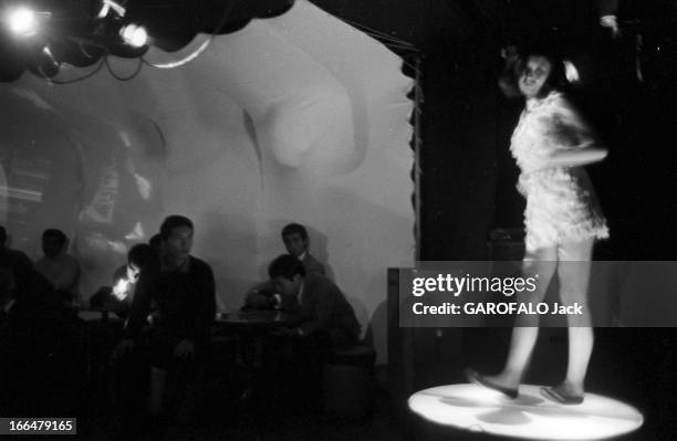 Japan. Japon, 14 octobre 1968, une jeune femme danse seule devant des hommes attablés dans un club.