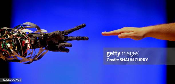 Science museum employee plays a child's game of 'paper, scissors, stone' with BERTI the robot at the Science Museum, in London on February 17, 2009....