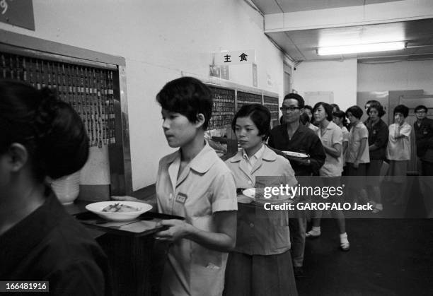 Japan. Japon, 14 octobre 1968, la cantine de l'entreprise 'Sony', avec les employés portant des badges avec leur nom, en file indienne avec leur...