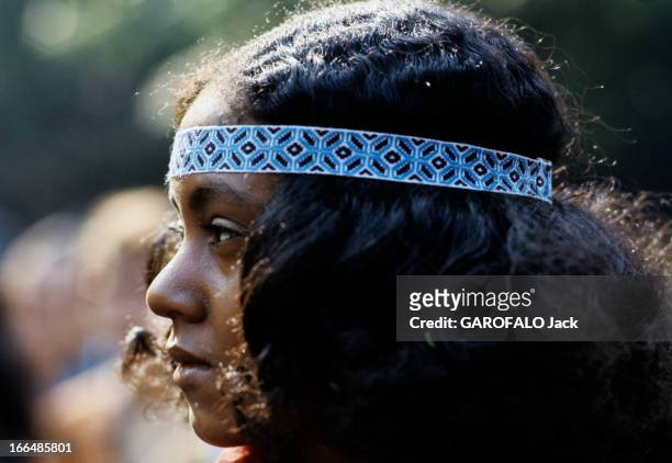 The Ghetto. New York City- Harlemle ghetto; portrait d'une jeune femme portant un bandeau dans ses cheveux longs frisés.