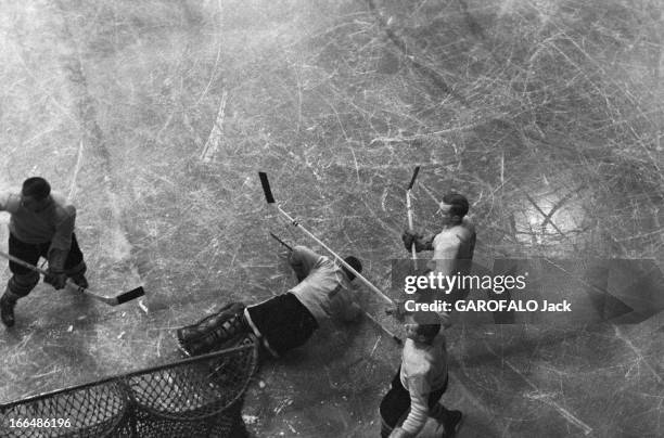 Ice Hockey. Décembre 1955- Un match de hockey sur glace: chute d'un joueur sur la glace.