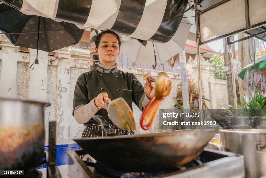 タイの旧市街のストリートマーケットで中華鍋で「パッタイ」を作る自信のある女性。