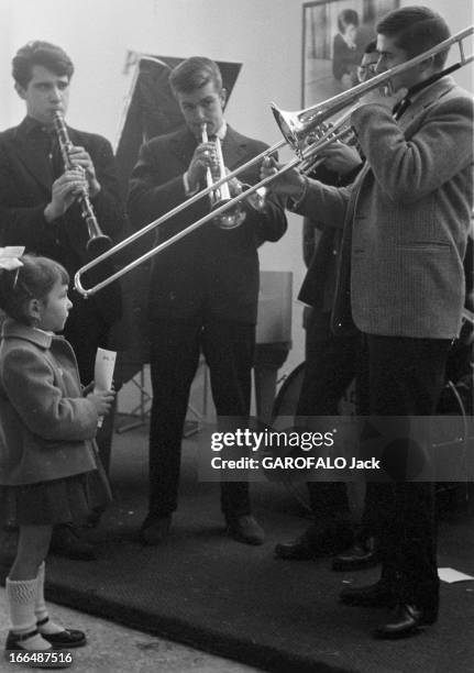 6Th Childhood Fair 1953. Paris, novembre 1953, le 6ème Salon de l'Enfance 1953 au Grand Palais. Une petite fille écoute attentivement un orchestre.