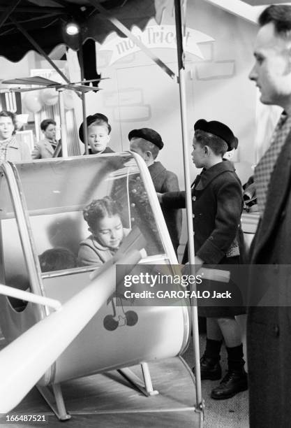 6Th Childhood Fair 1953. Paris, novembre 1953, le 6ème Salon de l'Enfance 1953 au Grand Palais. Sur un stand, une petite fille sur un manège. Des...