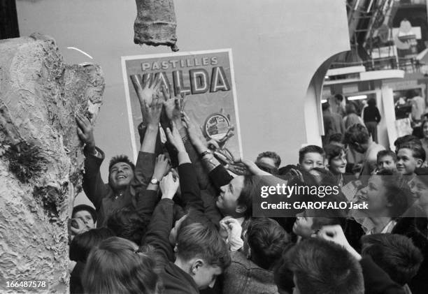 6Th Childhood Fair 1953. Paris, novembre 1953, le 6ème Salon de l'Enfance 1953 au Grand Palais. Devant un stand, un attroupement d'enfants, les bras...