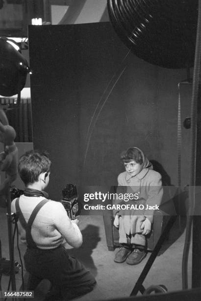 6Th Childhood Fair 1953. Paris, novembre 1953, le 6ème Salon de l'Enfance 1953 au Grand Palais. Sur un stand, une petite fille, assise sur un...