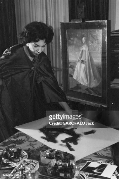 Close-Up Of Leonor Fini, Painter And Theater Decorator. Paris, décembre 1953, Léonor FINI, artiste peintre chez elle. Devant un tableau représentant...