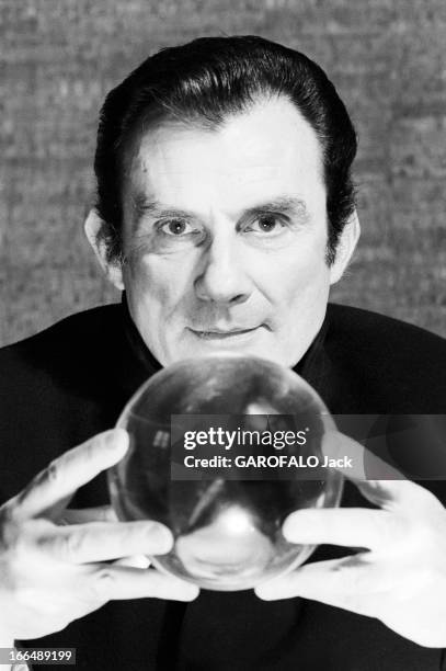 Jean Cau. 3 janvier 1977, portrait de l'écrivain et journaliste Jean CAU avec une boule de cristal.