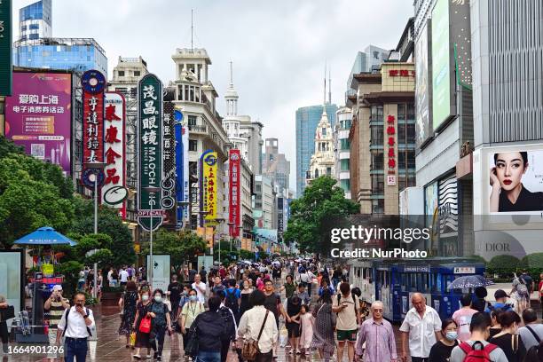 Tourists visit the Nanjing Road Walkway in the rain in Shanghai, China, September 14, 2023.