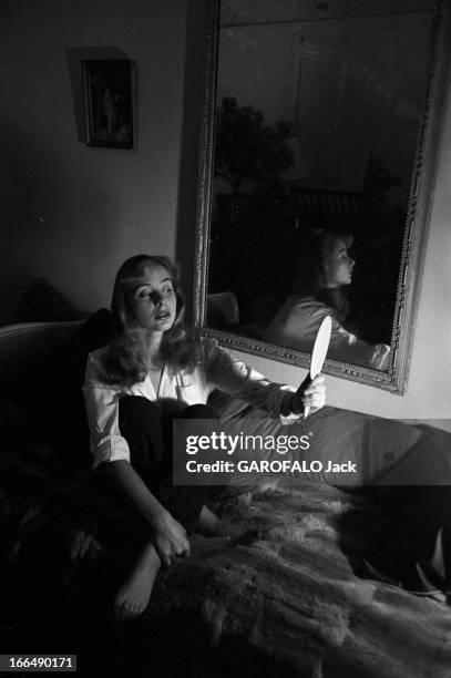 Close-Up Of Genevieve Page. Paris- Février 1954- Close-up Geneviève PAGE, jeune comédienne: celle-ci en pantalon et chemisier blanc, posant assise...