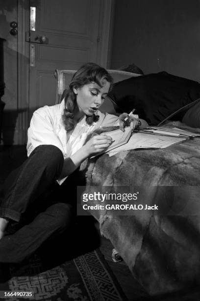 Close-Up Of Genevieve Page. Paris- Février 1954- Close-up Geneviève PAGE, jeune comédienne: celle-ci en pantalon et chemisier blanc, posant assise au...