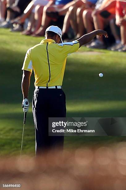 Tiger Woods of the United States drops his ball after he hits it into the water on the 15th hole during the second round of the 2013 Masters...