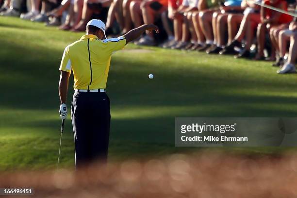 Tiger Woods of the United States drops his ball after he hits it into the water on the 15th hole during the second round of the 2013 Masters...