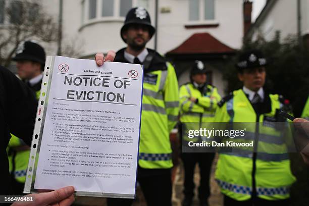 An eviction notice is held up as UK UNCUT supporters protest over the government's changes to the welfare system and the proposed 'Bedroom Tax,' on...