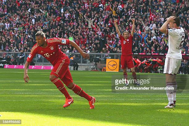Jerome Boateng of Muenchen celebrates scoring the opening goal with his team mate Anatoliy Tymoshchuk whilst Timmy Simons of Nuernberg reacts during...