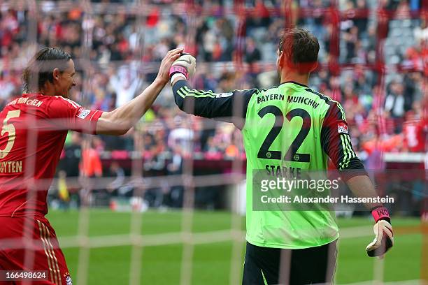 Tom Starke, keeper of Muenchen reacts with his team mate Daniel van Buyten after a penalty safe during the Bundesliga match between FC Bayern...