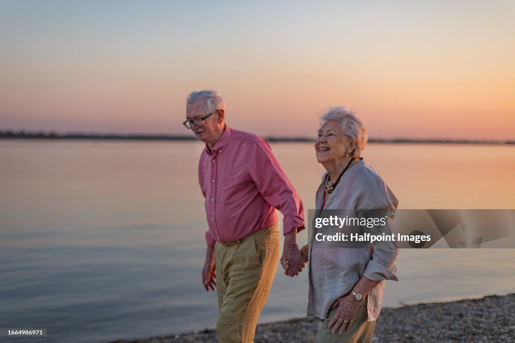 A senior couple enjoying summer vacation by the sea, celebrating their wedding anniversary.