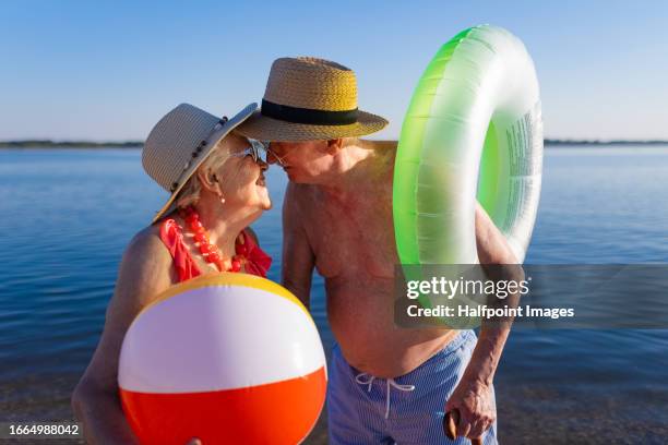 a senior couple enjoying summer vacation by the sea, celebrating their wedding anniversary. - happy anniversary stock-fotos und bilder