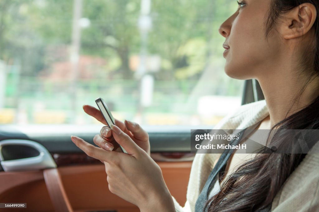 Woman with mobile phone in the car
