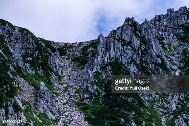 japanese high mountain rock wall and climber in summer - senjojiki cirque stock pictures, royalty-free photos & images