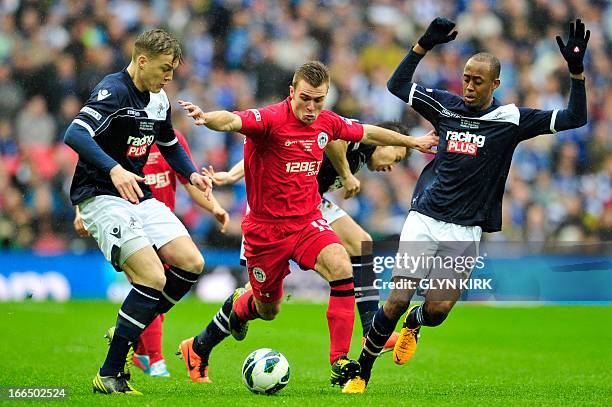 Millwall's Australian defender Shane Lowry and Millwall's French-born Comorian midfielder Nadjim Jimmy Abdou vie with Wigan Athletic's English...