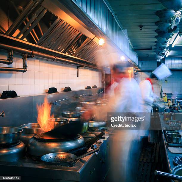 interior of a restaurant kitchen with busy chefs - blurred motion restaurant stock pictures, royalty-free photos & images