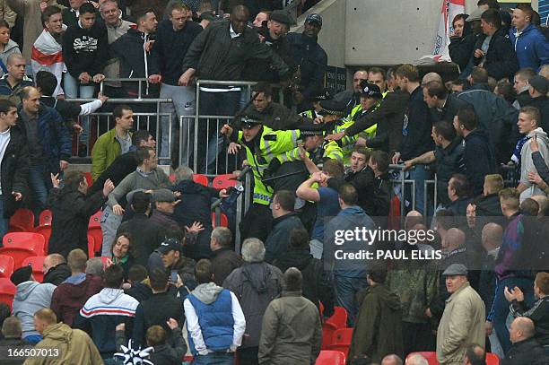 Police clash with supporters of Millwall during the FA Cup semi-final football match between Millwall and Wigan Athletic at Wembley Stadium in north...