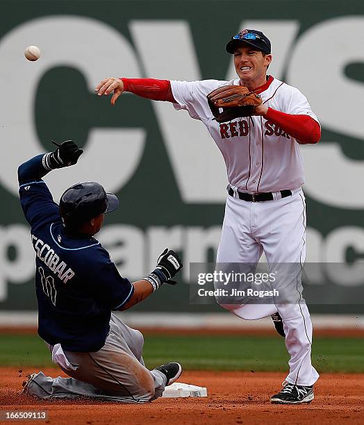 Yunel Escobar of the Tampa Bay Rays slides as Stephen Drew of the Boston Red Sox turns a double play in the seventh inning at Fenway Park on April...