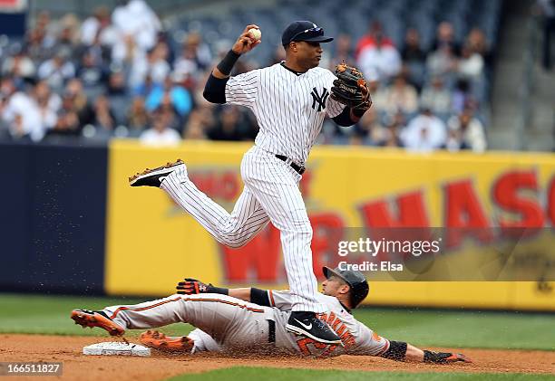 Nick Markakis of the Baltimore Orioles is out at second but Robinson Cano of the New York Yankees is unable to turn the double play in the first...