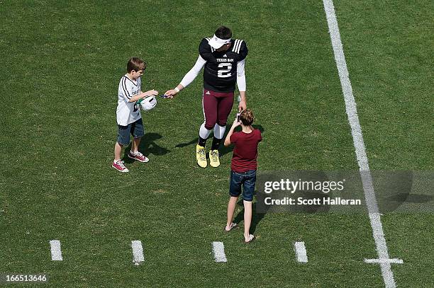 Texas A&M Aggies quarterback Johnny Manziel signs an autograph for a fan after the Maroon & White spring football game at Kyle Field on April 13,...