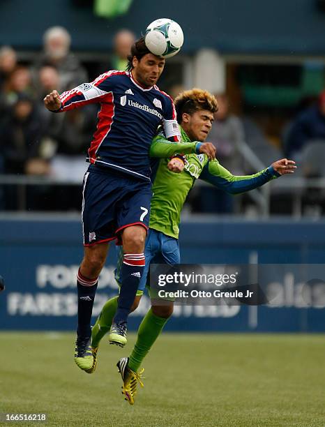 Juan Toja of the New England Revolution heads the ball against DeAndre Yedlin of the Seattle Sounders FC at CenturyLink Field on April 13, 2013 in...