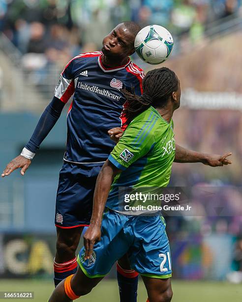 Kalifa Cisse of the New England Revolution heads the ball against Shalrie Joseph of the Seattle Sounders FC at CenturyLink Field on April 13, 2013 in...