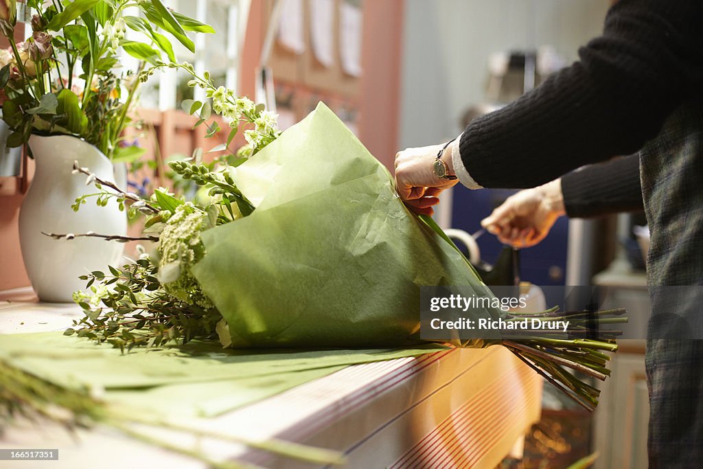 Florist in her shop preparing bouquet of flowers