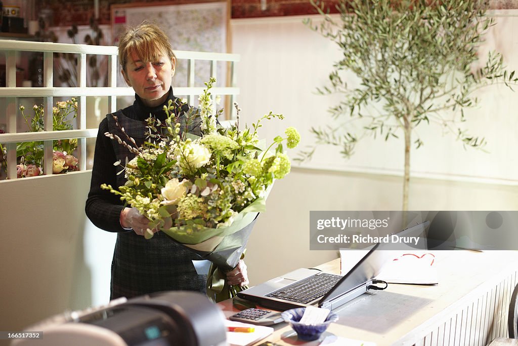 Florist checking bouquet of flowers