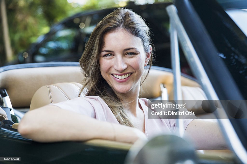 Portrait of woman in classic convertible car