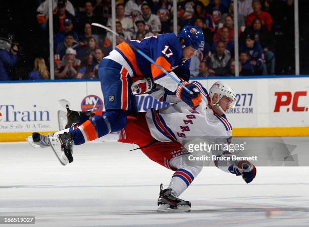 Matt Martin of the New York Islanders hits John Moore of the New York Rangers during the first period at the Nassau Veterans Memorial Coliseum on...