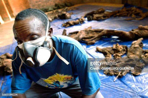 One of the Nyamata Genocide Memorial Site's guardians, Rwema Epimaque sits 29 March 2004 in Nyamata Church, near some recently discovered bodies from...