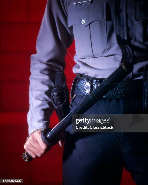 1990s Torso only of policeman security guard holstered gun on his hip holding nightstick.