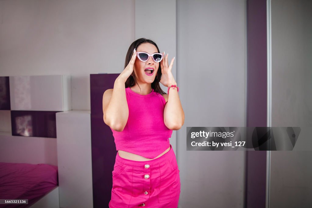 A Beautiful Gen Z Girl Wearing Hot Pink Clothes And Pink Sunglasses Posing  In Front Of The Mirror In Her Bedroom High-Res Stock Photo - Getty Images