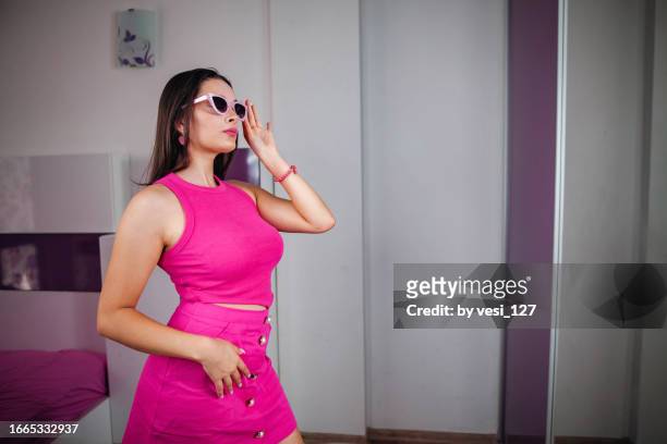 A Beautiful Gen Z Girl Wearing Hot Pink Clothes And Pink Sunglasses Posing  In Front Of The Mirror In Her Bedroom High-Res Stock Photo - Getty Images