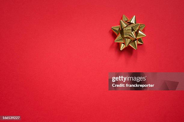 gold bow on christmas red background - gift box stock pictures, royalty-free photos & images