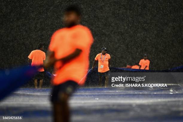 Ground staff cover the field as it rains during the Asia Cup 2023 Super Four one-day international cricket match between Sri Lanka and Pakistan at...