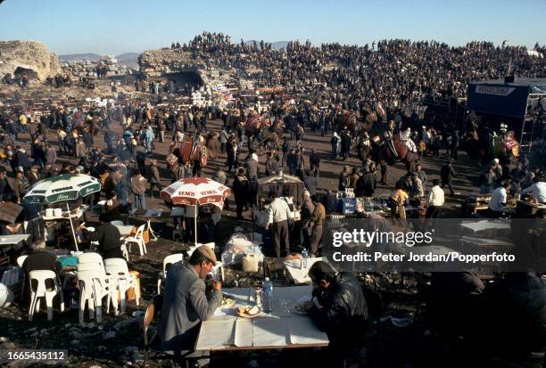 Spectators eat at tables in the arena during the annual Yoruk camel wrestling festival held in a stadium beside the ancient city of Ephesus near the...