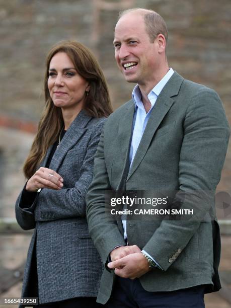 Britain's Prince William, Prince of Wales and Britain's Catherine, Princess of Wales react during a visit to Kings Pitt Farm in Hereford, western...