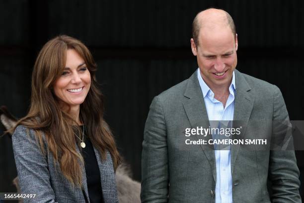 Britain's Prince William, Prince of Wales and Britain's Catherine, Princess of Wales react during a visit to Kings Pitt Farm in Hereford, western...
